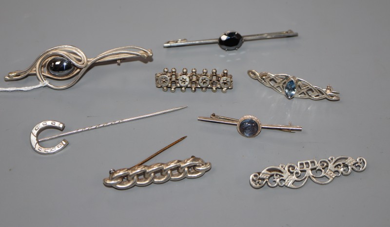 Eight assorted white metal brooches etc,